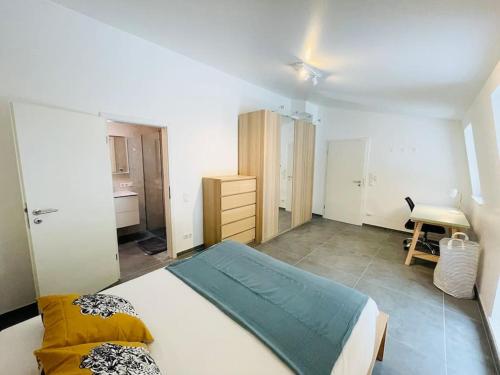 a bedroom with a large white bed and a desk at Penthouse 3 bedrooms in center w. private garden in Luxembourg
