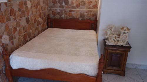 małe łóżko z drewnianą ramą i stolikiem nocnym w obiekcie KANALU w mieście Bouillante