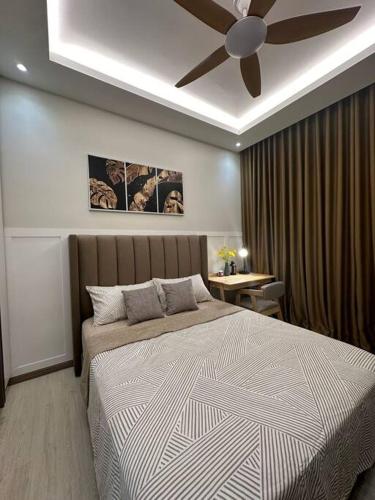 a bedroom with a bed with a ceiling fan at Sunset View at Modern Home in Kuala Lumpur