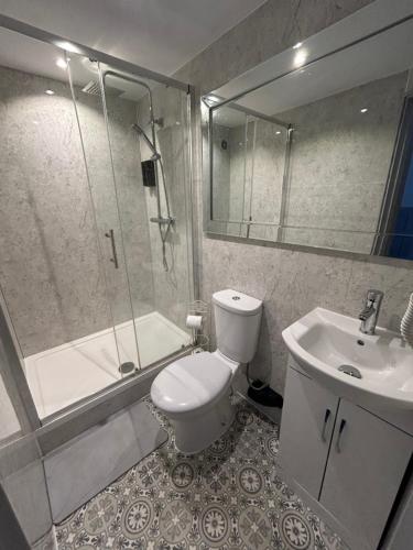 a bathroom with a toilet and a shower and a sink at The Studios in Hempstead