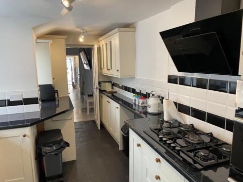 a kitchen with white cabinets and a stove top oven at 5 bed, 5 bath New refurbishment for 2024. Sleeps 16, 60 yds beach & harbour in Weymouth