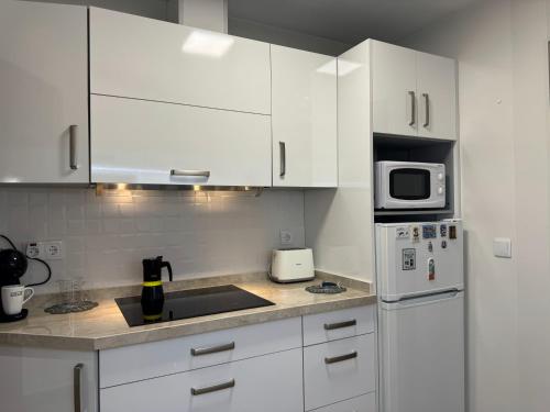 cocina blanca con armarios blancos y microondas en Apartamento Mar del Sur en Benalmádena