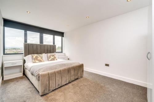a bedroom with a large bed with a large window at ENTERPRISE APARTS in Bradford