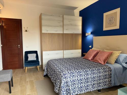 1 dormitorio con cama y pared azul en Apartamento Mar del Sur, en Benalmádena
