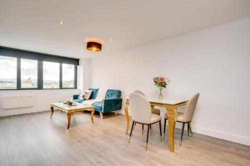a living room with a table and chairs and a couch at ENTERPRISE APARTS in Bradford