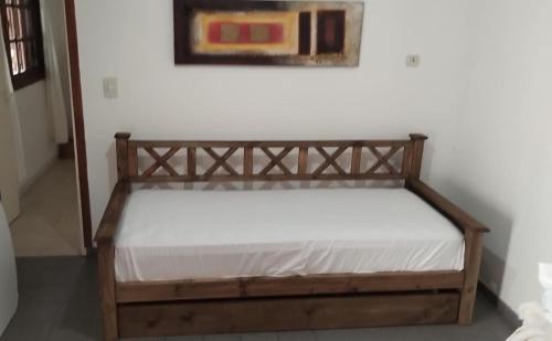 a bed with a wooden frame in a room at Departamento MDP 4personas max in Mar del Plata