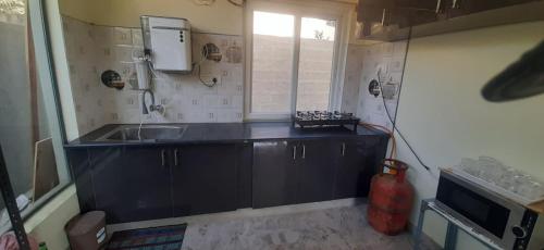 a small kitchen with a sink and a window at NHC full cottage in Nandi