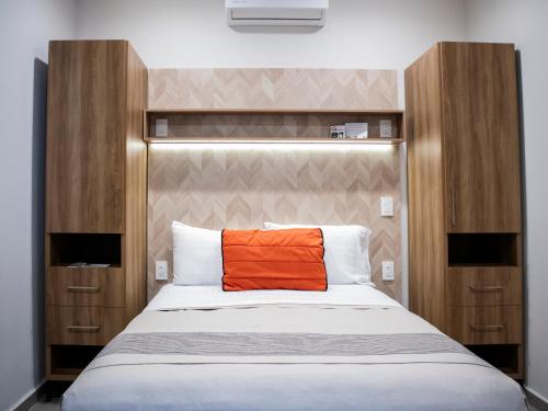 una almohada naranja sobre una cama en Hotel Mayis, en Oaxaca City