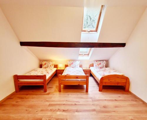 Zimmer im Dachgeschoss mit 2 Betten und einem Fenster in der Unterkunft Ferienwohnung Naturoase Quasthoff in Neustadt an der Weinstraße