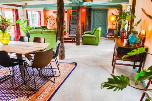 uma sala de estar com mesa e cadeiras em BoHo Experience Wellness, Jacuzzi, Sauna, BBQ, Garden, Sleeps 10 em Kockengen