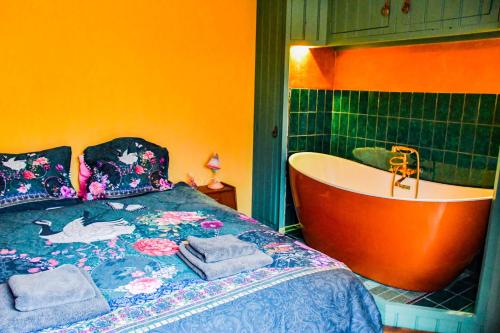 um quarto com uma cama e uma banheira em BoHo Experience Wellness, Jacuzzi, Sauna, BBQ, Garden, Sleeps 10 em Kockengen