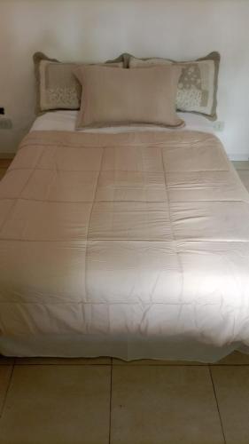 1 cama grande con sábanas y almohadas blancas en Departamento MDP (Para 4 personas Maximo) en Mar del Plata