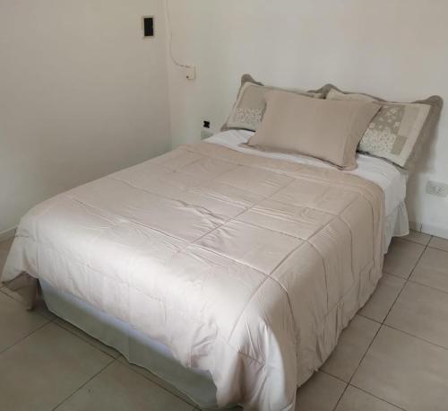 1 cama con sábanas blancas y almohadas en una habitación en Departamento MDP (Para 4 personas Maximo) en Mar del Plata