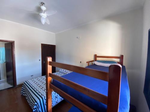 a bedroom with two bunk beds and a ceiling fan at Casa do Bert Pousada in Itanhaém