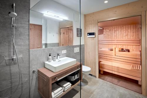 y baño con lavabo, aseo y ducha. en Luxusapartment mit Sauna am Berg en Sankt Ulrich am Pillersee