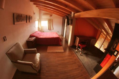 Habitación con 1 cama y 1 silla en una habitación en Departamento Loft completo, cómodo y luminoso. en Neuquén