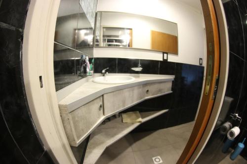y baño con lavabo y espejo. en Departamento Loft completo, cómodo y luminoso. en Neuquén