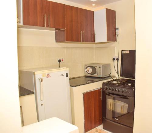 a small kitchen with a refrigerator and a microwave at Fully furnished One bedroom bnb in Thika Town. in Thika
