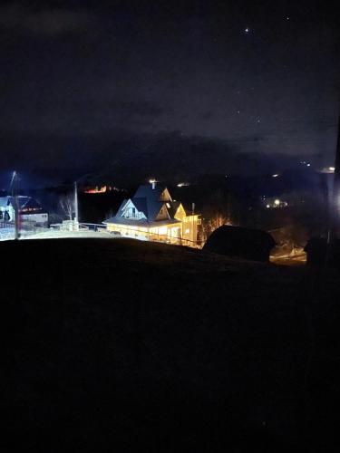 a house on a hill at night at Carpathia Magic -adults only in Peştera
