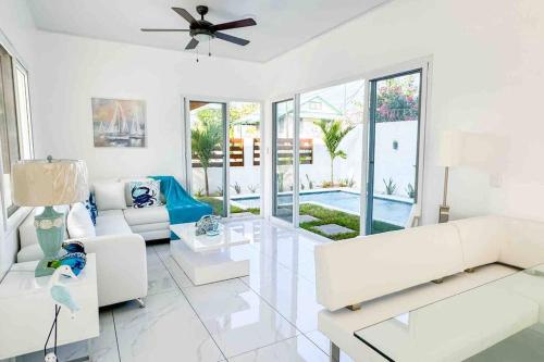 a living room with white furniture and a ceiling fan at Atlantis Villages Poseidon in Tela