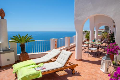 d'un balcon avec des chaises blanches et une vue sur l'océan. dans l'établissement Villa Poesia, à Praiano