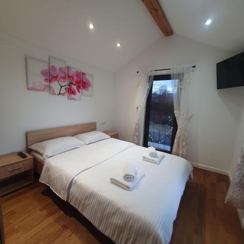 a bedroom with a bed with two towels on it at La casa din deal in Vişeu de Sus
