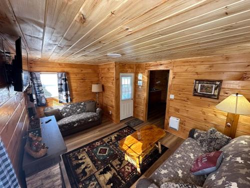 einen Blick über ein Wohnzimmer in einem Blockhaus in der Unterkunft Rowe's Adirondack Cabins of Schroon Lake in Schroon Lake