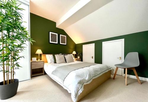 a bedroom with green walls and a bed and a chair at 1 Bed - Sleeps 4 - Parking - 15 mins Gatwick in Crawley