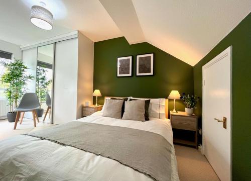 um quarto com paredes verdes e uma cama grande em Charming home near Gatwick Airport em Crawley