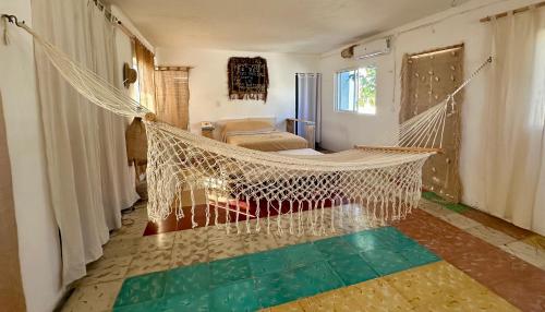 een kamer met een hangmat in een kamer bij UcúLila in Sisal