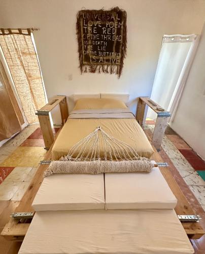 2 camas en una habitación con un cartel en la pared en UcúLila, en Sisal