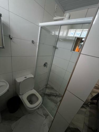 ein Badezimmer mit Toilette und Glasdusche in der Unterkunft Hotel Delavy in Chapecó