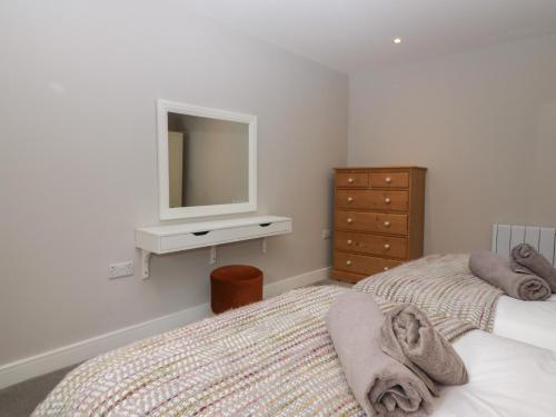 a bedroom with two beds and a dresser and a mirror at Grizedale in Kendal