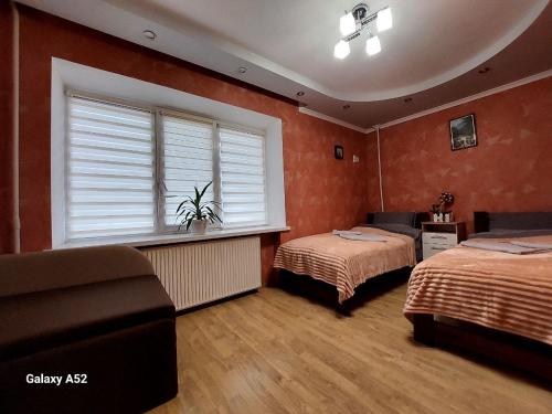a bedroom with two beds and a window and a couch at Подобова оренда двокімнатної квартири Старичі in Starychi