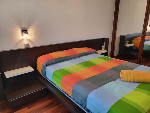 Cama colorida en habitación con espejo en Apto. Vista Bahía Santander, en Pontejos
