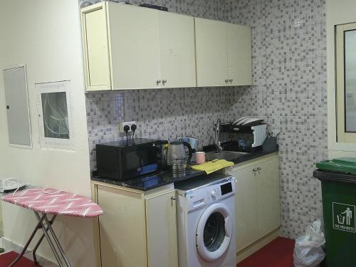 a kitchen with a washing machine and a microwave at Ruby Star Hostel Dubai Couples Partition 303 in Dubai