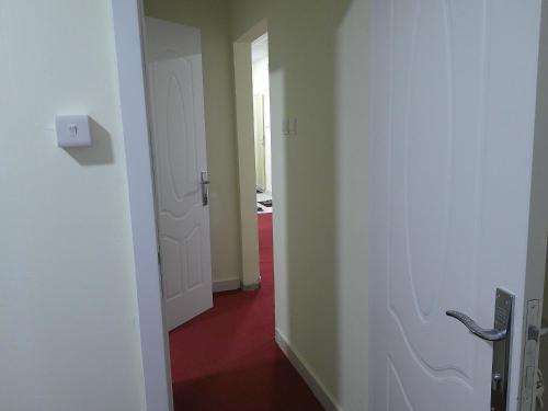 a hallway with two doors and a red floor at Ruby Star Hostel Dubai Couples Partition 303 in Dubai