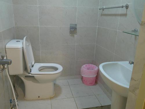 La salle de bains est pourvue de toilettes, d'un lavabo et d'une baignoire. dans l'établissement Ruby Star Hostel Dubai Couples Partition 303, à Dubaï