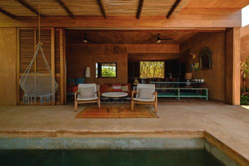 a patio with a table and chairs next to a pool at Mazul Puerto Escondido in Tlachicón