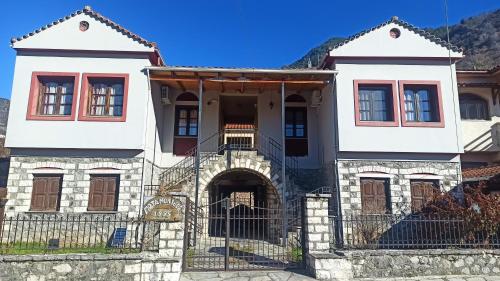 an old house with a gate in front of it at Potamolithos Suites 2 in Konitsa