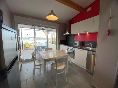 une cuisine avec une table et des chaises ainsi qu'une salle à manger dans l'établissement Gîte T2 avec Terrasse et Parking - Proche des Thermes - FR-1-503-147, à Balaruc-les-Bains