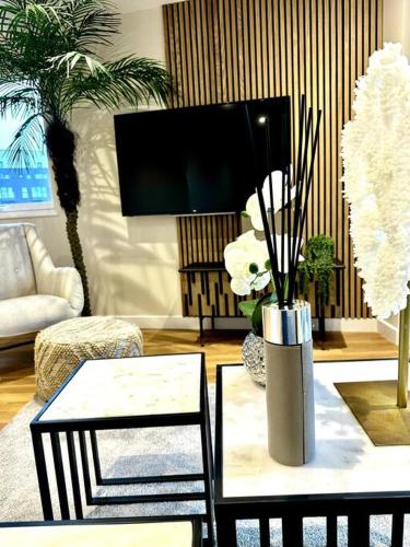 a living room with a tv and a vase with flowers at Exclusive Marina View Apartment Free Parking in Cardiff