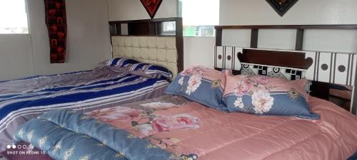 1 dormitorio con 2 camas y almohadas rosas y azules en casa ecológica, en Puno