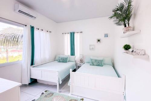 Dieses weiße Zimmer verfügt über 2 Betten und ein Fenster. in der Unterkunft Atlantis Luxury Villages - Neptun in Tela