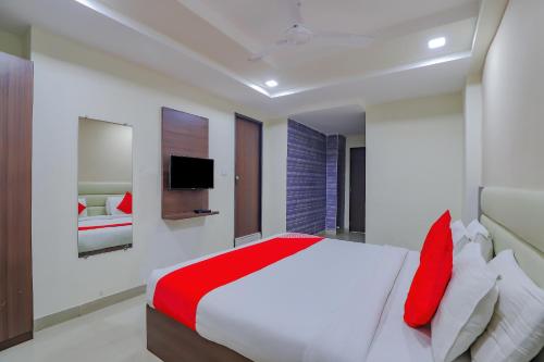 een slaapkamer met een groot bed met rode kussens bij Collection O Greenwood in Ahmedabad