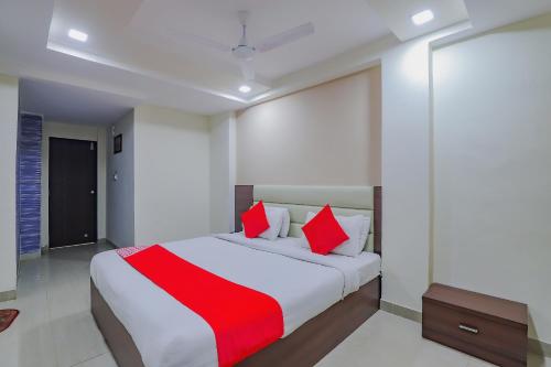 een slaapkamer met een groot bed met rode kussens bij Collection O Greenwood in Ahmedabad
