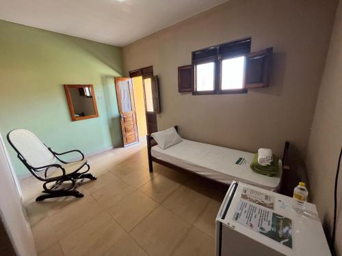 Habitación hospitalaria con cama y silla en Hotel Fazenda Brejo, en Saloá