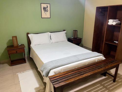 a bedroom with a bed and a wooden bench at Hotel Fazenda Brejo in Saloá