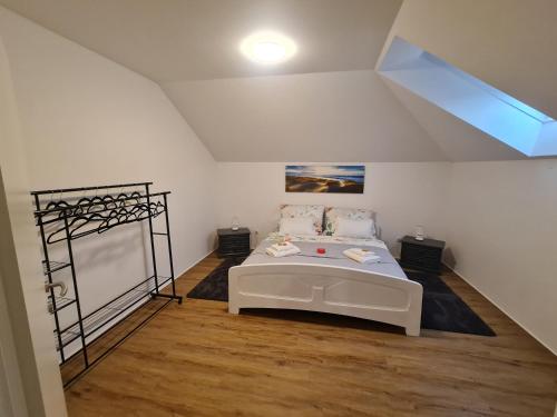 ein Schlafzimmer mit einem weißen Bett im Dachgeschoss in der Unterkunft Ferienwohnung Traisen Has in Traisen