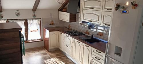 a kitchen with white cabinets and a stove top oven at Casa David in Gura Hangului